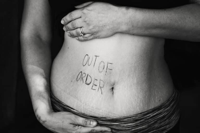 Womans abdomin with the words 'out of order' writtein on it indicating digestive problems in menopause