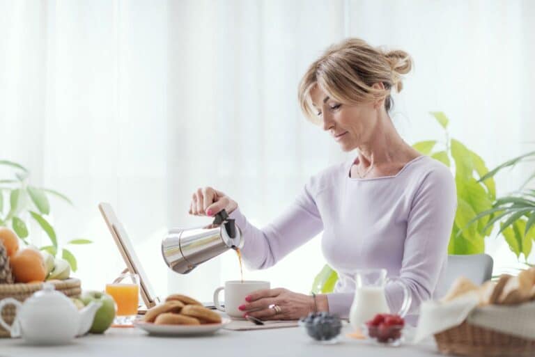 Woman pouring morning coffee wondering is she eating enough for menopause